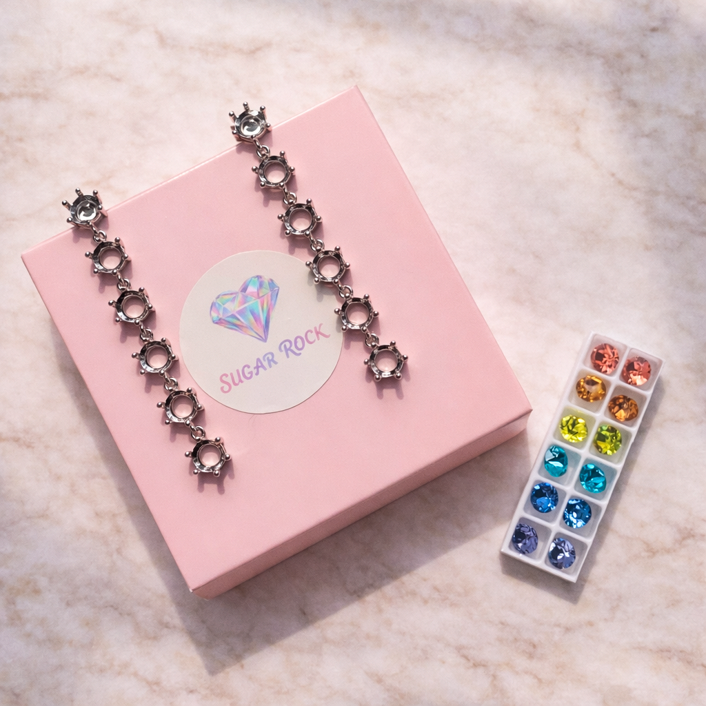 Necklace with decorative elements on a pink box, next to a small tray of colorful stones.