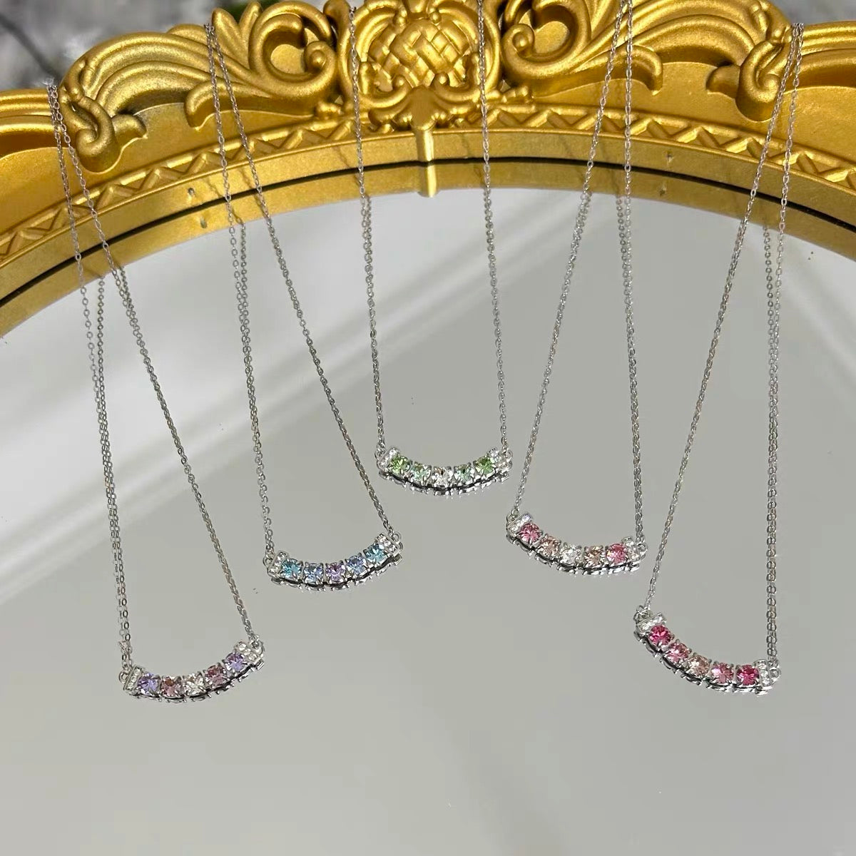 Set of four necklaces with colorful stones on a gold frame