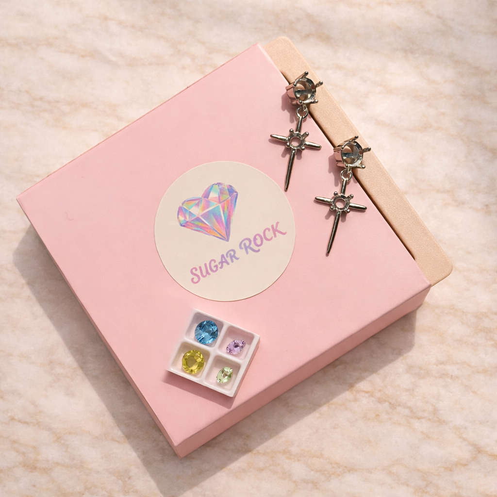 Pink box with 'Sugar Rock' label, earrings, and gemstones on a beige surface
