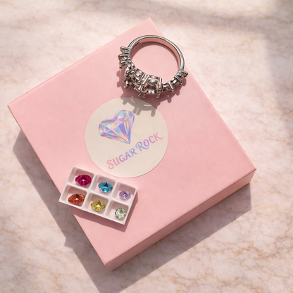Rhythm Ring with gemstones and 'SUGAR ROCK' label on a pink box